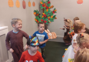 Dzieci w przebraniach bawiące się na balu jesieni.