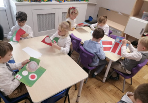 Dzieci wykonujące biało-czerwone kotyliony.