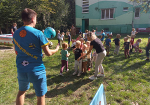 Dzieci grające w piłkę w ogrodzie przedszkolnym.