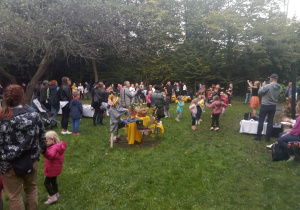 Rodzice i dzieci na pikniku przedszkolnym.