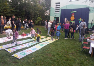 Rodzice i dzieci na pikniku przedszkolnym.
