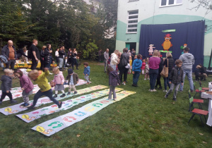 Rodzice i dzieci na pikniku przedszkolnym.
