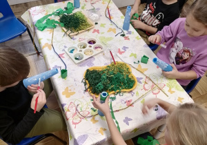 Dzieci wykonujące pracę plastyczną choineczki.