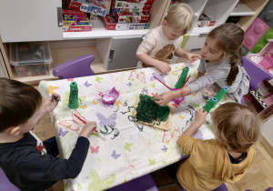 Dzieci wykonujące pracę plastyczną choineczki.