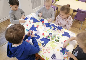 Dzieci przygotowujące ozdoby świąteczne.