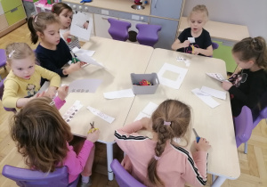 Dzieci pracujące przy stolikach.