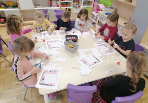 Dzieci pracujące przy stolikach.