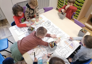 Dzieci pracujące przy stolikach.