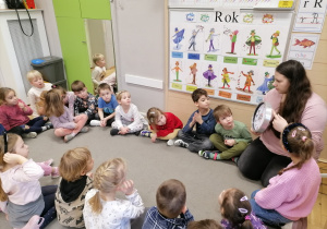 Dzieci siedzące na dywanie podczas zajęć.