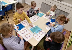 Dzieci wycinające paki przy stoliku.