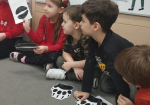 Dzieci siedzące w kole na zajęciach.