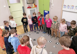 Dzieci siedzące w kole na zajęciach.