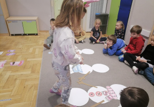 Dzieci układające bałwany na dywanie.