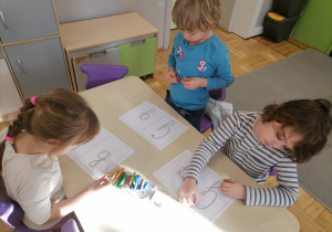 Dzieci wyklejające literę G za pomocą plasteliny.