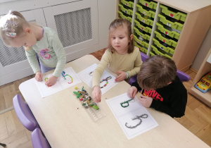 Dzieci wyklejające literę G za pomocą plasteliny.