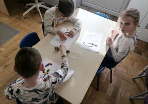 Dzieci wyklejające literę G za pomocą plasteliny.