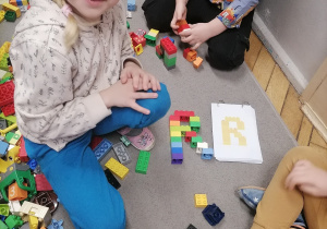 Dzieci układające klocki LEGO.