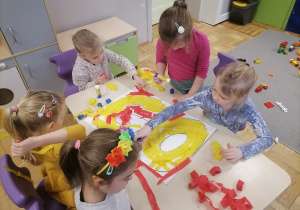 Dzieci wyklejające napis lego