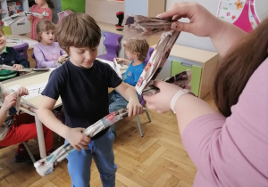 Dzieci tworzące literę Z z gazety.