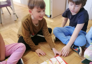 Dzieci układające puzzle z dinozaurami.