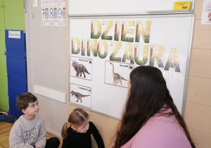 Dzieci przyczepiające dinozaury.