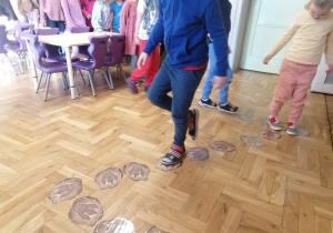 Dzieci chodzące po śladach dinozaurów.