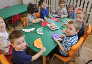 Dzieci malujące farbami przy stoliku.