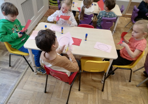 Dzieci wykonujące pracę plastyczną.