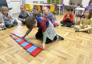 Chłopiec układający belki Montessori
