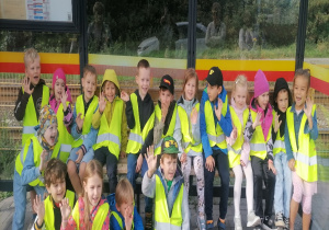 Dzieci pozują do zdjęcia na przystanku autobusowym