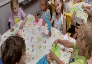 Dzieci składają latawce z papieru