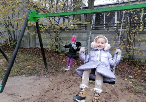 Dwie dziewczynki bujają się na huśtawkach