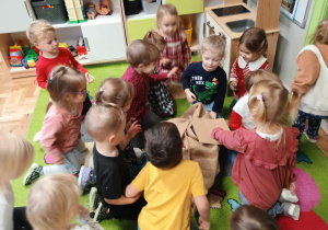 Dzieci otwierają prezent od Mikołaja