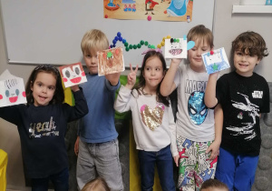Dzieci pozują do zdjęcia z wykonanymi przez siebie papierowymi pacynkami