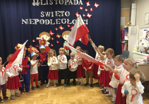 Dzieci ubrane w strojach biało- czerwonych występują w sali na uroczystości z okazji odzyskania przez Polskę Niepodległości.