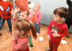 Dzieci trzymają białe i czerwone serca