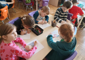 Dzieci przy stolikach kolorują