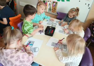 Dzieci przy stolikach kolorują