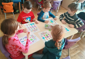 Dzieci przy stolikach BINGO gra