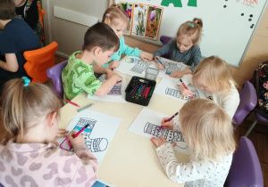 Dzieci przy stolikach kolorują