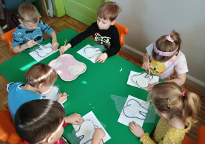 Dzieci malują białą farbą folię bąbelkową