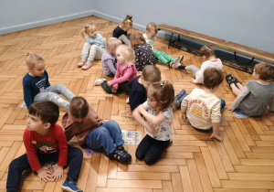 Dzieci siedzą na gazetach