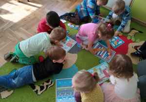 Dzieci przyczepiają elementy na rzepy do ilustracji