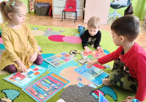 Dzieci przyczepiają na rzepy elementy do ilustracji