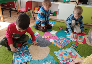 Dzieci przyczepiają na rzepy elementy do ilustracji