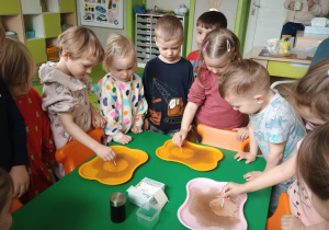 Dzieci dotykają patyczkiem do wody z pieprzem
