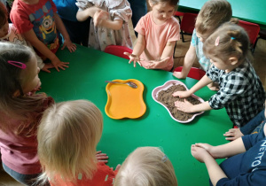 Dziewczynka kładzie ręce na pisku
