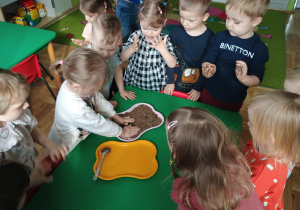 Dziewczynka kładzie ręce na pisku