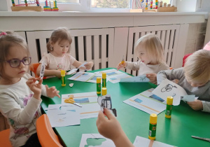Dzieci wycinają ilustracje z urządzeniami elektrycznymi