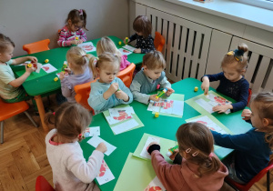 Dzieci układają obrazek z pociętych elementów